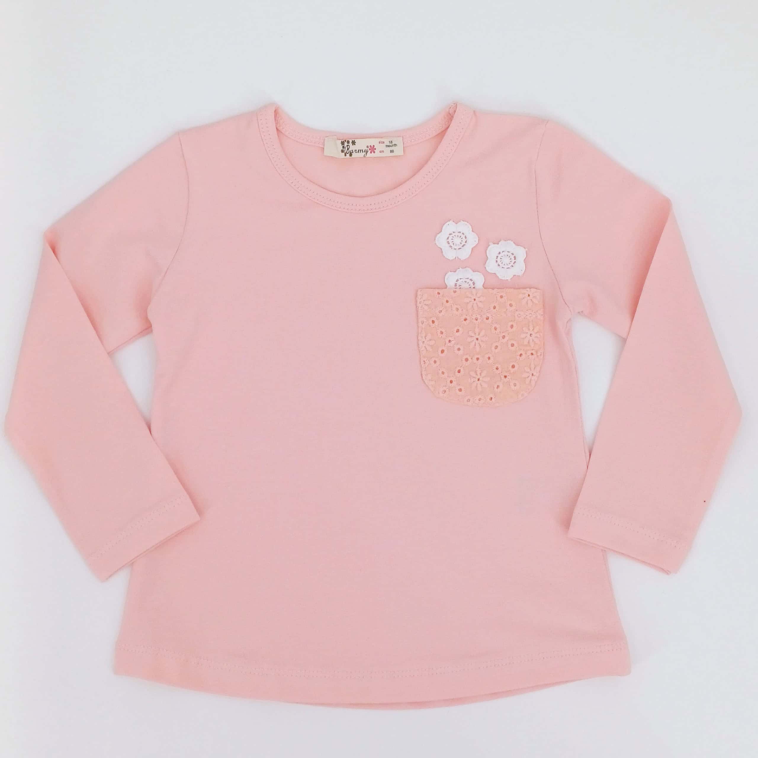 Cette charmante chemise pour enfants à manches longues en couleur pêche est parfaite pour les journées fraîches.