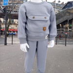 Ensemble hiver bébé gris avec pull et pantalon, doté d'une poche décorative et taille élastique. Disponible en tailles 9-12, 12-18, et 18-24 mois. Parfait pour garder votre enfant au chaud cet hiver.