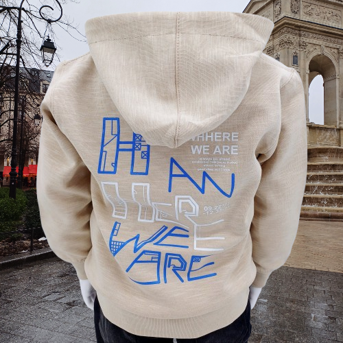 Sweat à capuche beige pour enfants avec impressions modernes bleues et blanches, disponible en tailles 1, 2, 3 et 4 ans. Idéal pour les journées fraîches et les promenades.