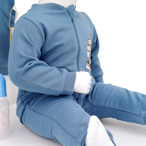 Pyjama bébé bleu indigo avec fermeture zippée et motif puzzle, fabriqué en coton bio, idéal pour l’hiver. Confortable et facile à enfiler.